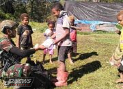 Prajurit Buaya Putih Kostrad Bagi-Bagi Buku Tulis Untuk Anak-Anak Kampung Kago